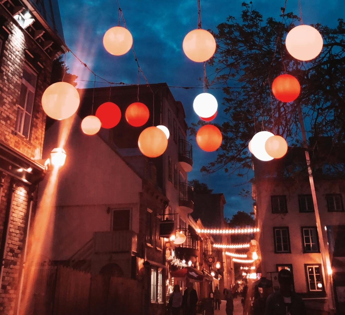 laneway of outdoor lights against night sky